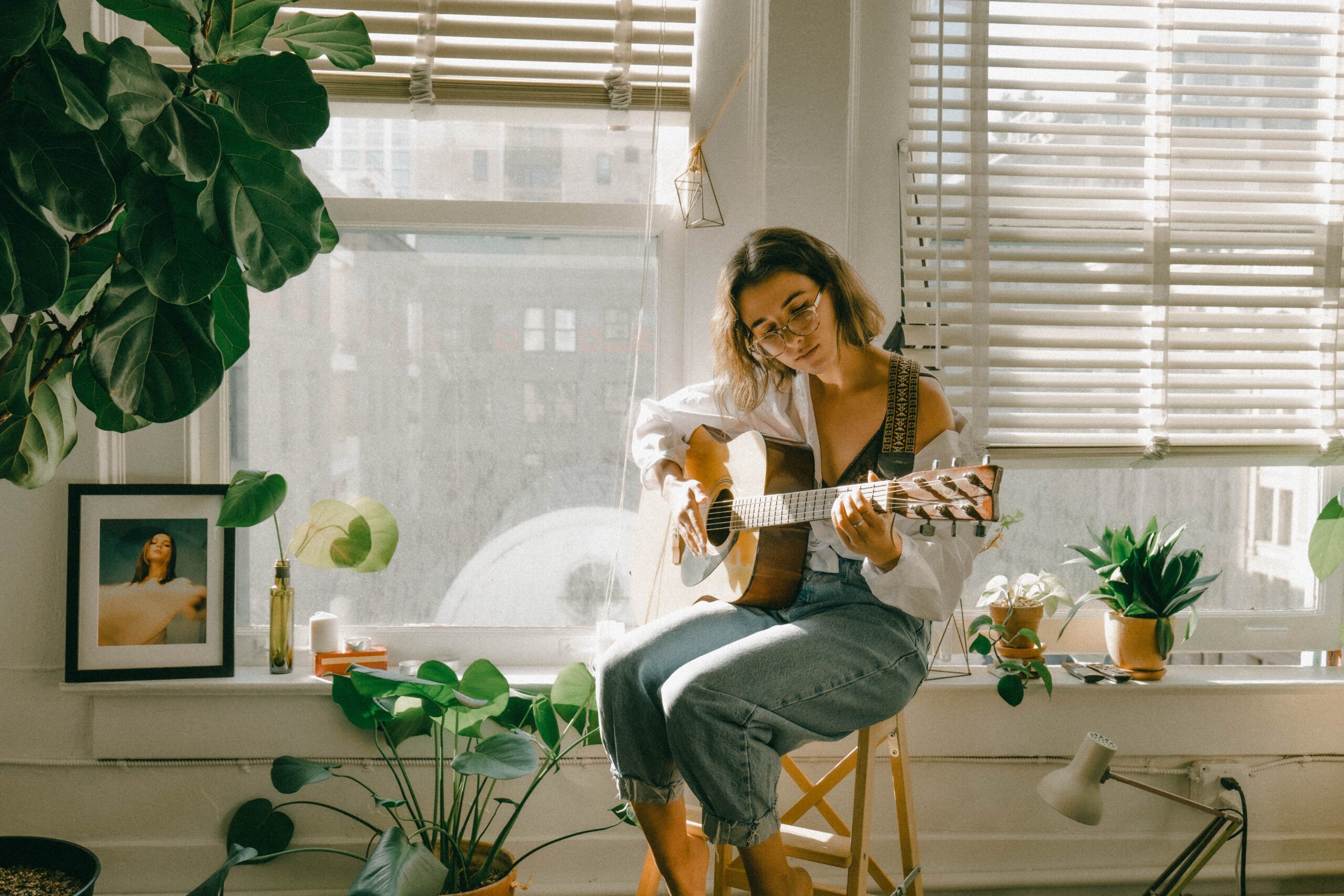 A female student practicing guitar in room