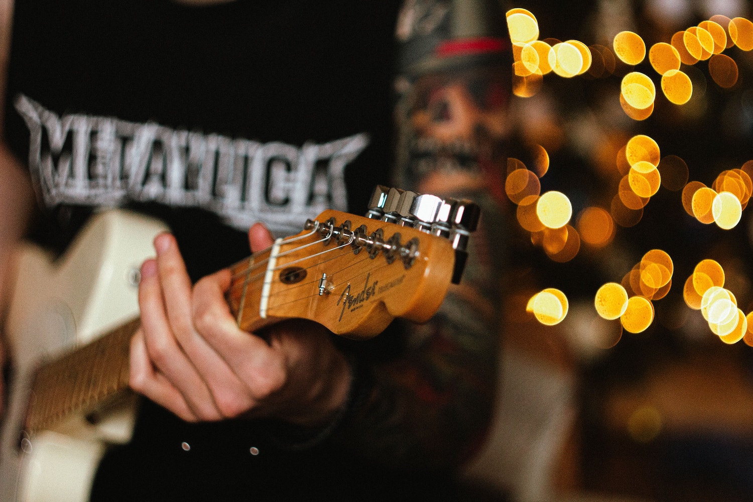 Guy wearing Metallica t-shirt, playing guitar